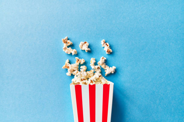 istock Pack of salty popcorns falling on a blue background 1356162745