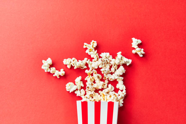 istock Pack of salty popcorns falling on a red background 1356162751