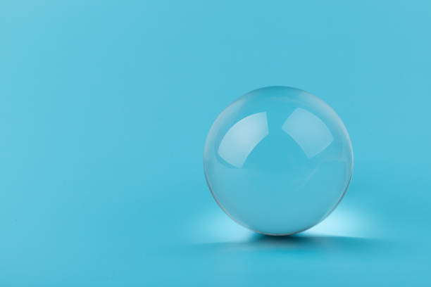 Crystal, transparent ball, sphere on  blue background. Glass.