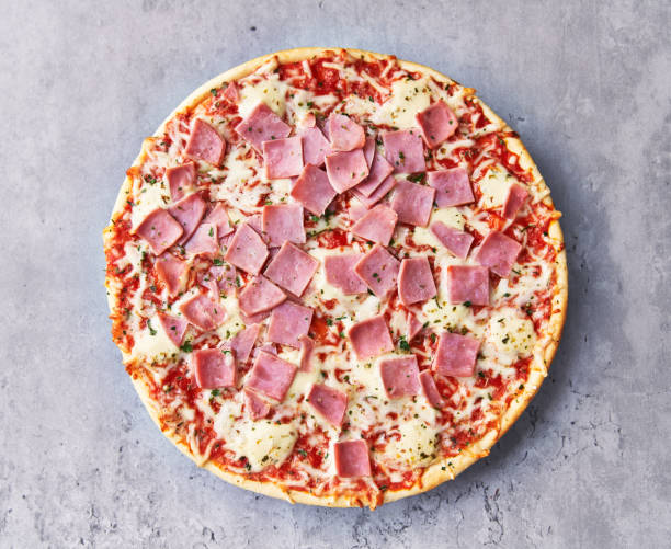 Delicious prosciutto italian pizza on a marble surface
