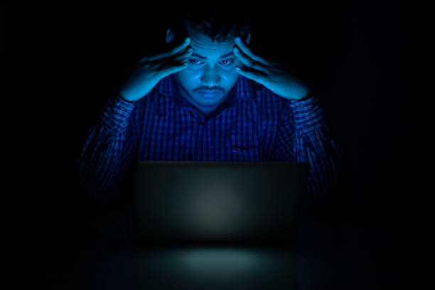 giovane uomo che si sente assonnato usando il computer portatile a metà notte - addiction internet computer working late foto e immagini stock