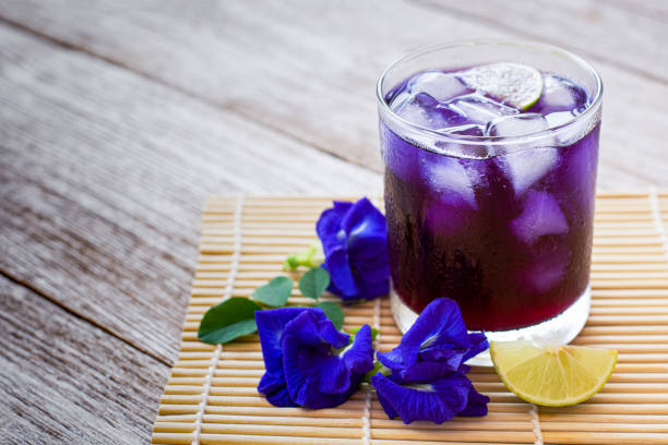 бабочка горох или голубой горох сок ледяной чай - pea flower стоковые фото и изображения