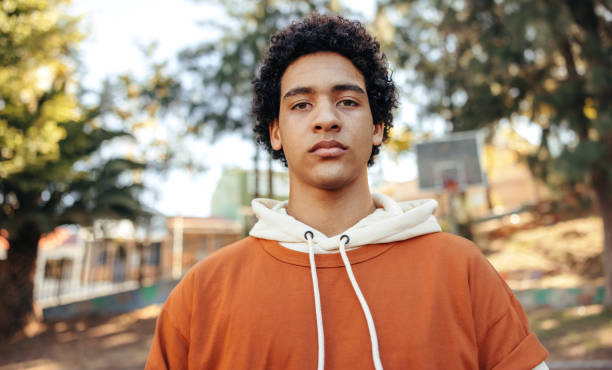 istock Teenage boy looking at the camera outdoors during the day 1356165541