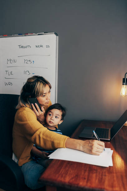 istock Busy mom writing notes during a business phone call 1356166050