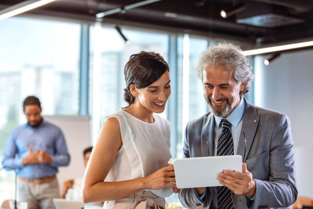 istock Male and female colleagues looking at tablet PC. 1356166859