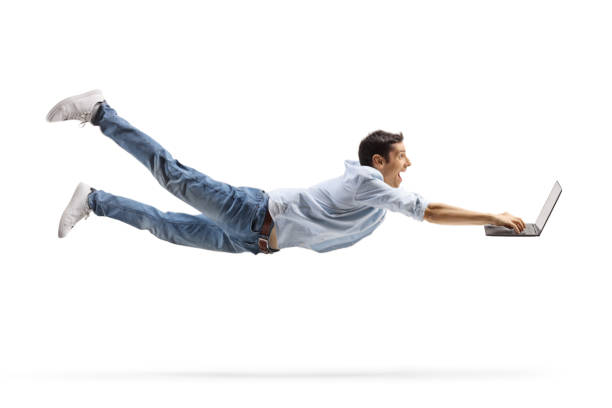 Young casual man flying and working on a laptop computer