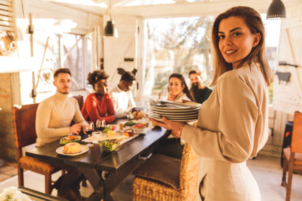 istock Young woman smiling at camera before setting up the table for dinner with friends 1356168294