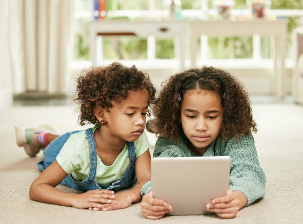 istock Shot of two sisters using a digital tablet at home 1356168909