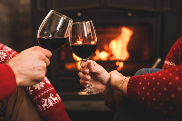istock Couple making a celebratory toast with red wine while relaxing by the cozy fireplace 1356170208