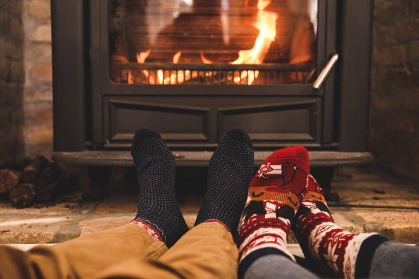 istock Couple warming their feet by the cozy fireplace 1356170219