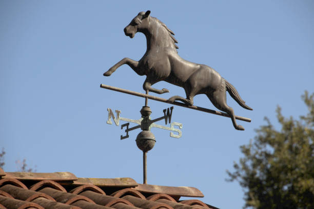 Arona, Italy - October 17, 2021: Metal wind-vane on domestic roof in the form of a galloping horse