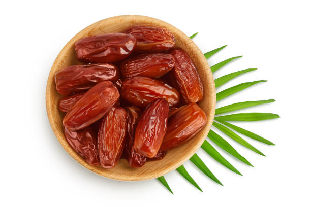 istock Dates in wooden bowl isolated on white background with clipping path. Top view. Flat lay 1356172973