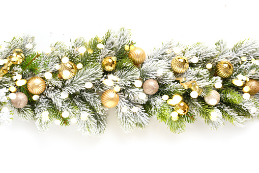 Christmas banner with gold baubles in row on snowy evergreen branches.