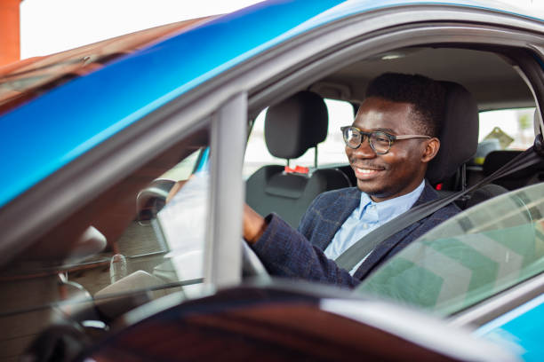 istock Attractive happy young man driving car and smiling. 1356174161