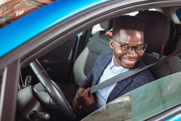 istock Man fastening seat belt in car. 1356174163