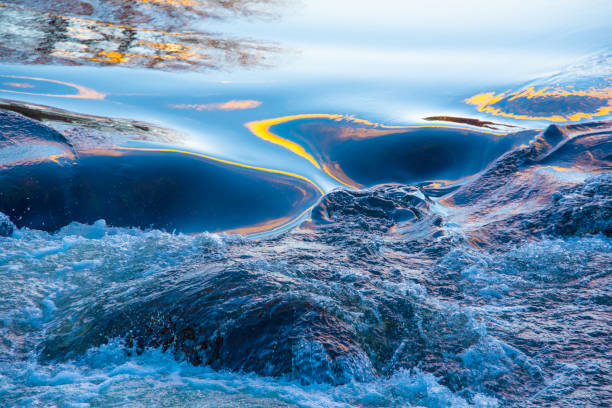 istock Light from the setting sun on the water-AuSable River, Michigan 1356176634