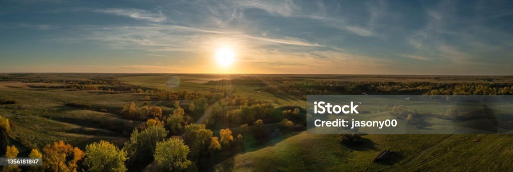 Aerial panorama of a sunset over the gentle rolling hills of the Great Plains with trees in their autumn colors Aerial panorama of a sunset over the gentle rolling hills of the Great Plains with trees in their autumn colors in North Dakota. Landscape - Scenery Stock Photo