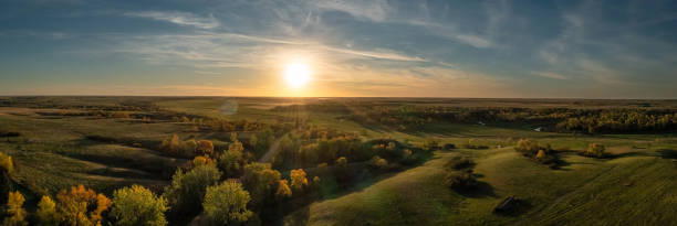 Aerial panorama of a sunset over the gentle rolling hills of the Great Plains with trees in their autumn colors Aerial panorama of a sunset over the gentle rolling hills of the Great Plains with trees in their autumn colors in North Dakota. north dakota stock pictures, royalty-free photos & images