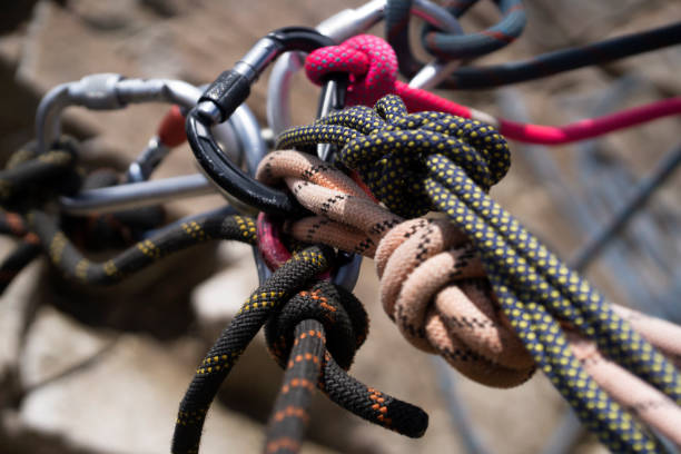 Carabiners and ropes in the mountains. Climbing accessories, tools, carabiners and ropes at the belay station in the mountains during the climb to the summit. carbine stock pictures, royalty-free photos & images