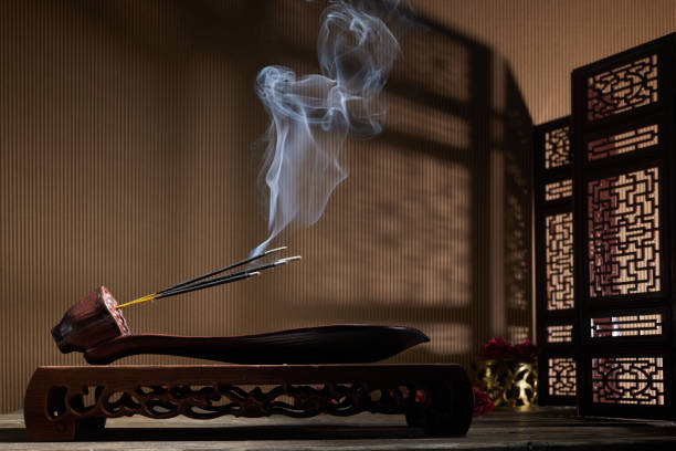 istock Smoke from burning incense sticks standing on lotus incense holder 1356185095