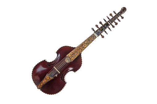 Seven stringed viola d'amore with sympathetic strings, dark wooden body, inlays and a carved child head, the musical instrument was played chiefly in the baroque period, isolated on a white background