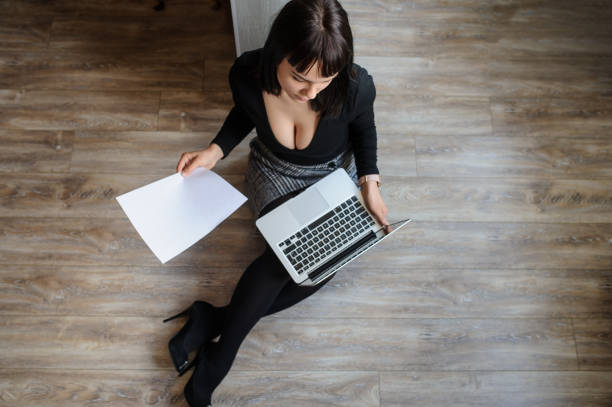istock young woman sitting on the floor and working on computer 1356188339