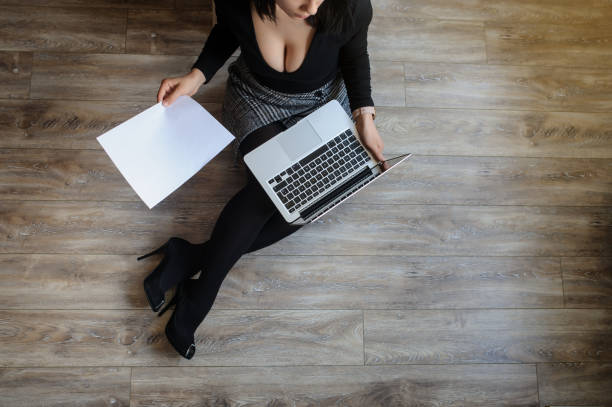 istock young woman sitting on the floor and working on computer 1356188457