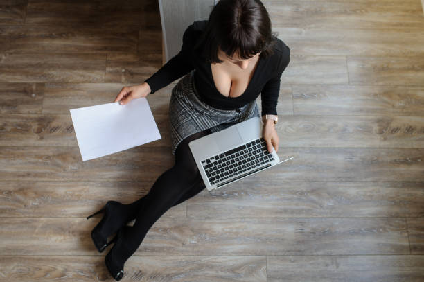 istock young woman sitting on the floor and working on computer 1356188602