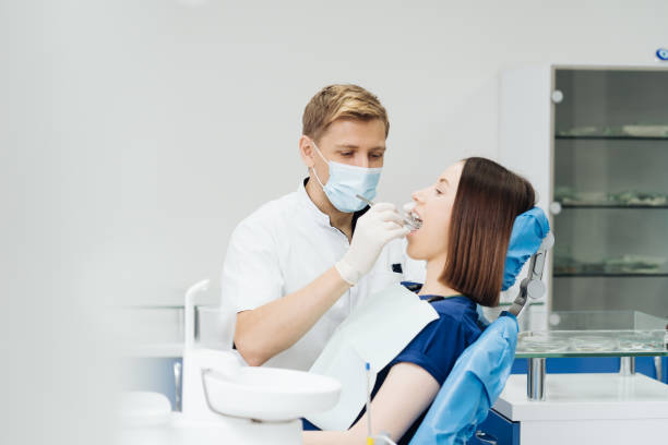 istock Dentist check patient cavity using instruments at clinic 1356189504