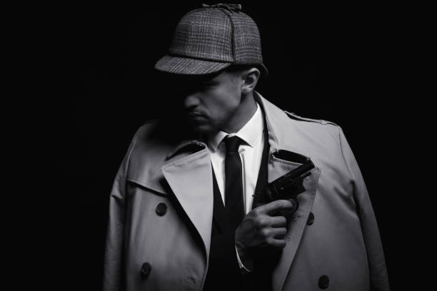 istock Old fashioned detective with revolver on dark background, black and white effect 1356190807