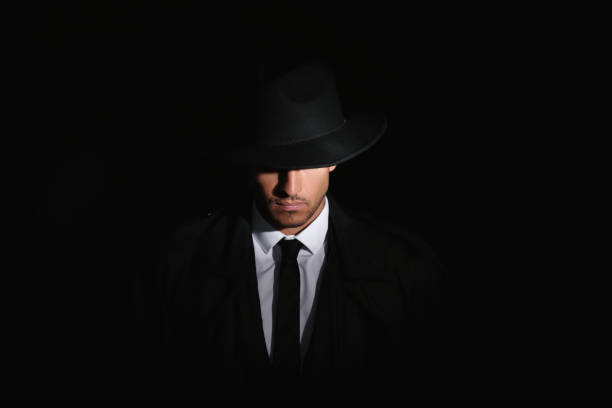 istock Old fashioned detective in hat on dark background 1356190903