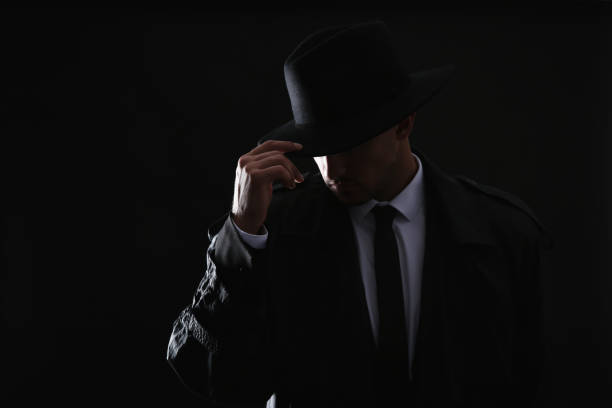 istock Old fashioned detective in hat on dark background 1356191104