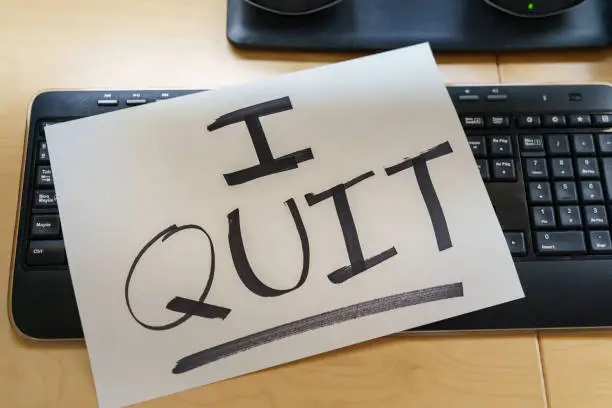 Photo of Note on a keyboard with the text I QUIT. Great resignation concept