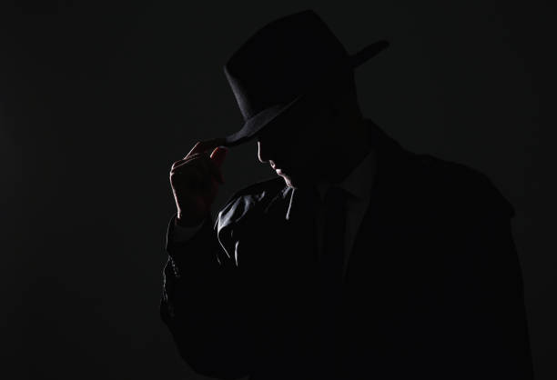 istock Old fashioned detective in hat on dark background 1356191434