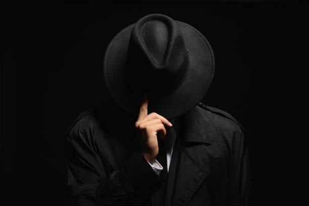 istock Old fashioned detective in hat on dark background 1356192421