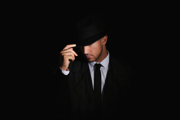 istock Old fashioned detective in hat on dark background 1356192614