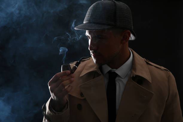 istock Old fashioned detective smoking pipe on dark background 1356193363