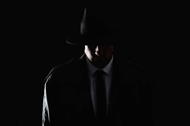 istock Old fashioned detective in hat on dark background 1356193513