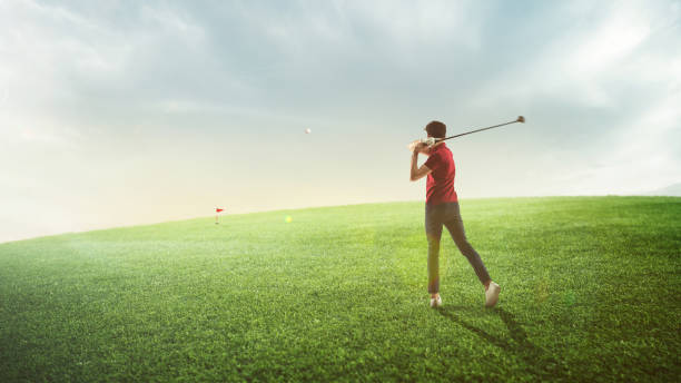 junger mann, golfspieler im roten hemd, der einen schwung nimmt, spielt golf auf dem feld an sonnigen sommertagen, im freien. - golf golf course swinging isolated stock-fotos und bilder