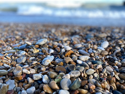 Tiny rocks along the shoreline of a Lake Michigan beach with bokeh background.