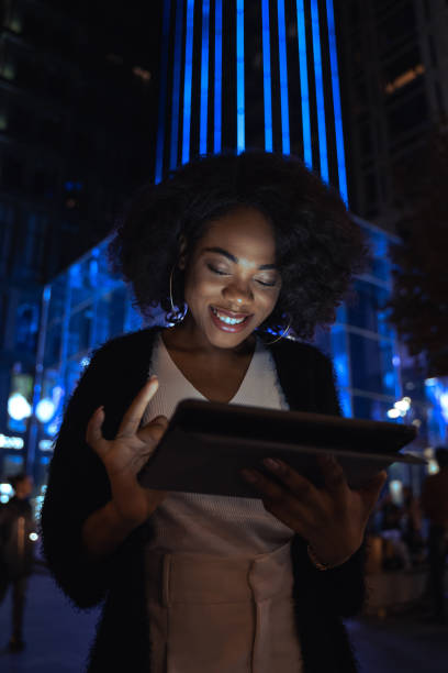 istock Woman holding tablet at her hands and looking at screen while working at the night time 1356194861
