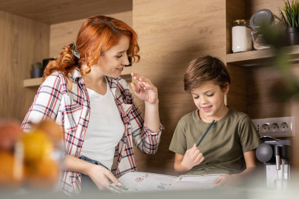 istock Mother helping son with homework 1356195189