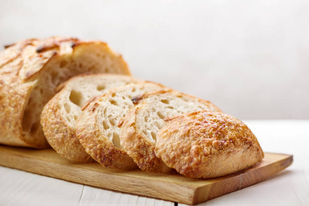 istock Close up of sliced wheat bread on board selective focus. 1356195277