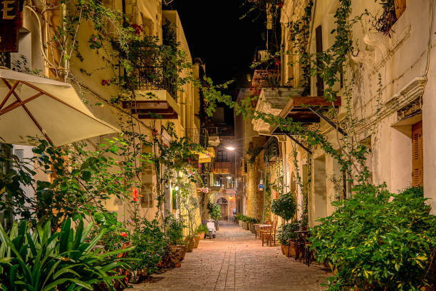 The illuminated alley Antoni Gampa with green plants and balconies in the old town of Chania stock photo