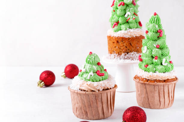 Christmas tree cupcakes decorated with sugar sprinkles Christmas tree cupcakes decorated with sugar sprinkles and shredded coconut on the white table. Holiday serving size dessert christmas cake stock pictures, royalty-free photos & images