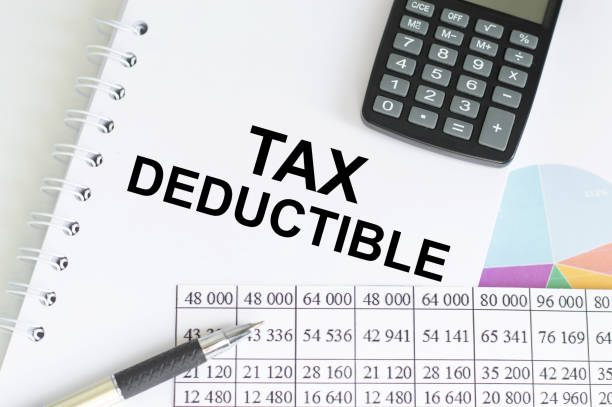 text tax deduction on a notepad among charts and reports on the table. business and financial concept - subtraction imagens e fotografias de stock