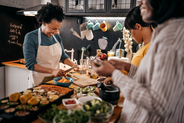 istock Three female friends cooking food in kitchen 1356197725