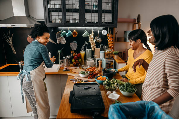 istock Three female friends cooking food in kitchen 1356197743