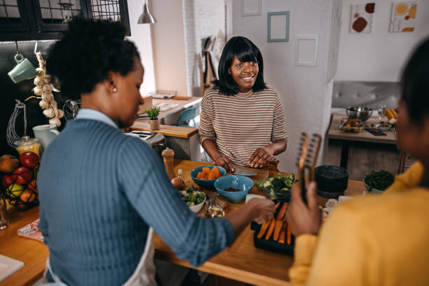 istock Three female friends cooking food in kitchen 1356197810