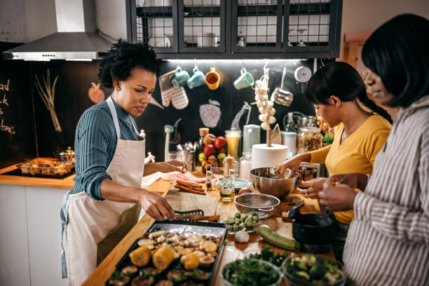 istock Three female friends cooking food in kitchen 1356197928